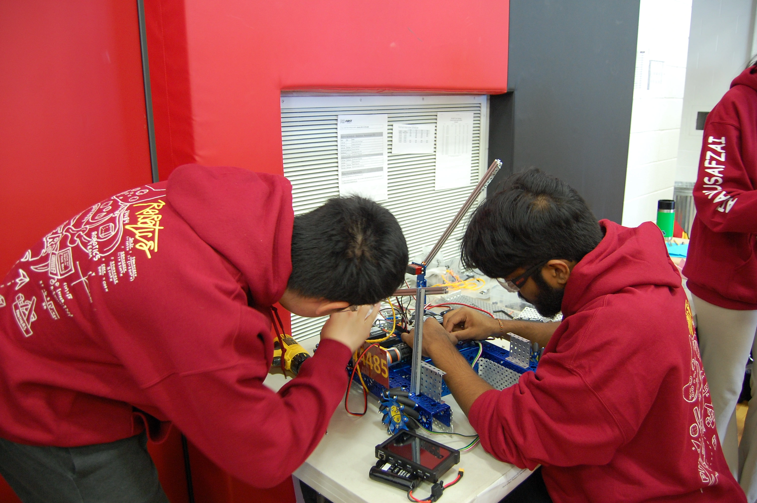 Team members connecting robot electronics